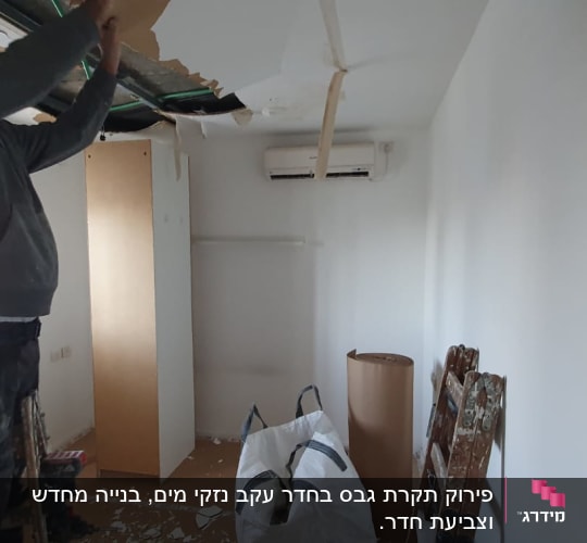 אדם מפרק תקרת גבס בחדר קטן